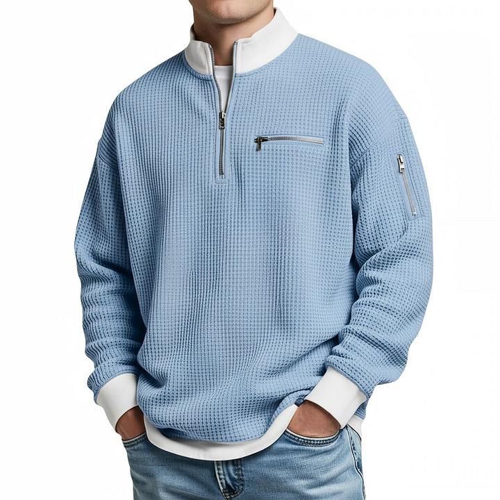 Front view of a light blue waffle knit quarter-zip sweater with a white collar and cuffs.