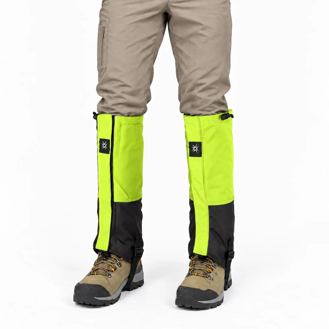 Front view of lime green and black gaiters worn over tan pants and brown hiking boots on a white background. 6
