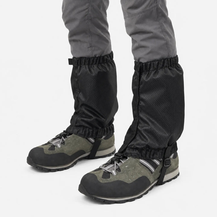 Black ripstop gaiters on a model's lower legs, seen from a side angle, with elastic top and bottom and a boot strap. 5