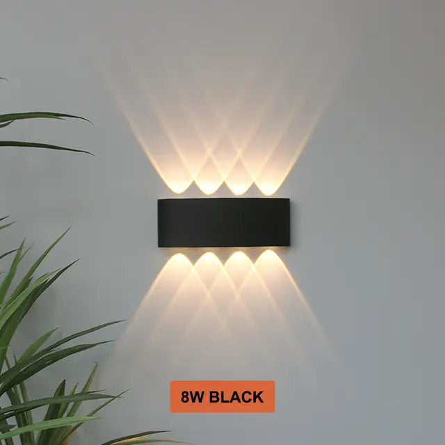 Black Skøle wall light fixture detail with four openings per side projecting a diamond pattern of beams