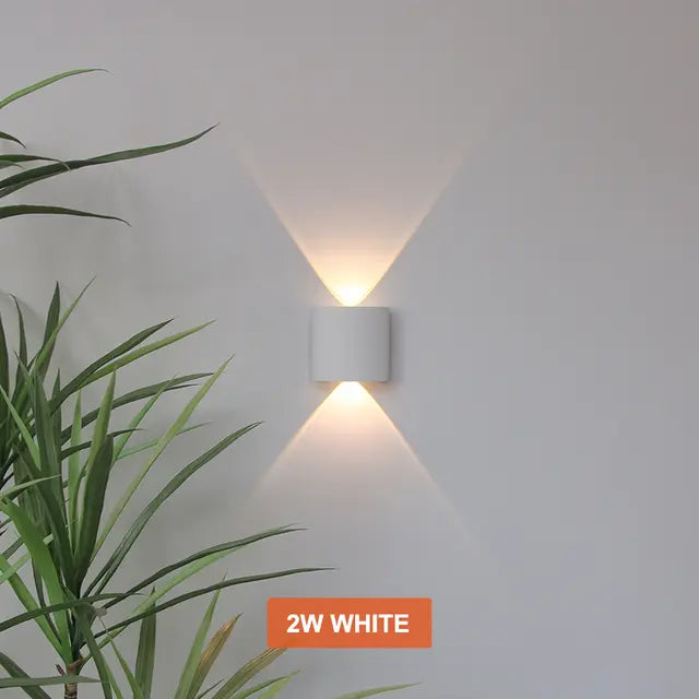 White Skøle wall light fixture detail glowing warm with narrow beams above and below