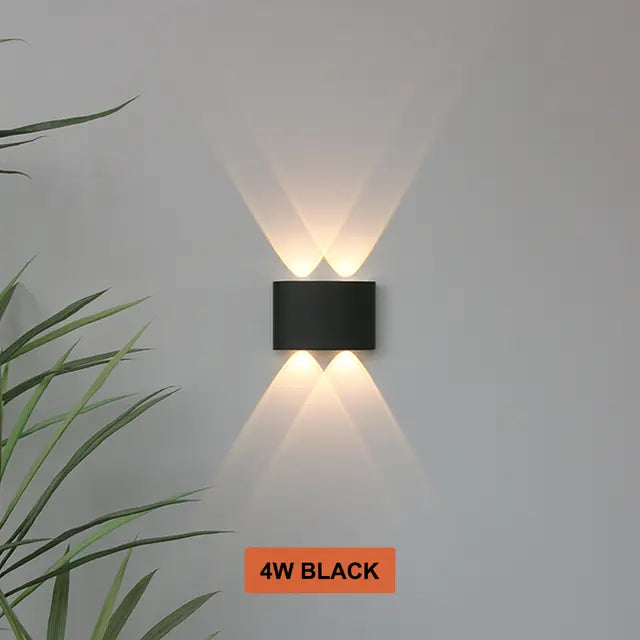 Black Skøle wall light fixture detail with two openings per side casting overlapping beams