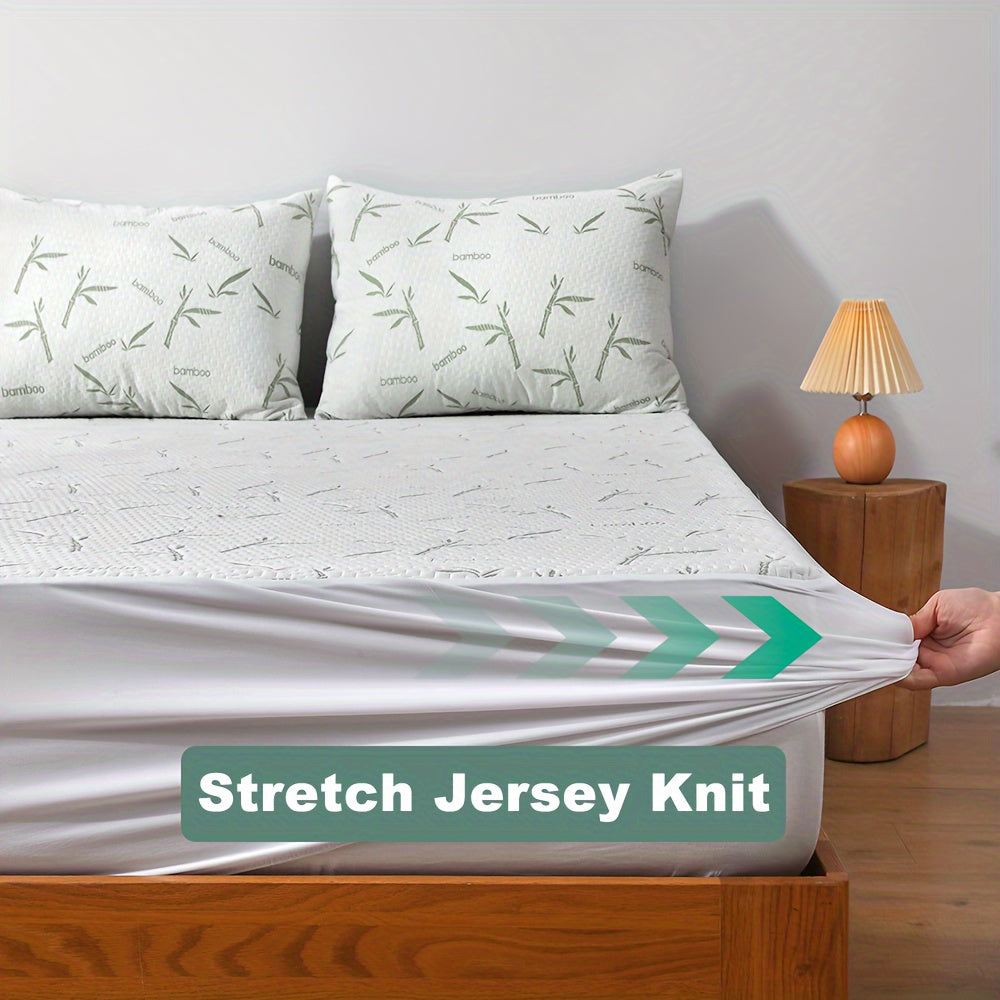 Mattress protector fitted on a bed beside two matching bamboo-print pillows, with a hand stretching the white jersey knit skirt. 3