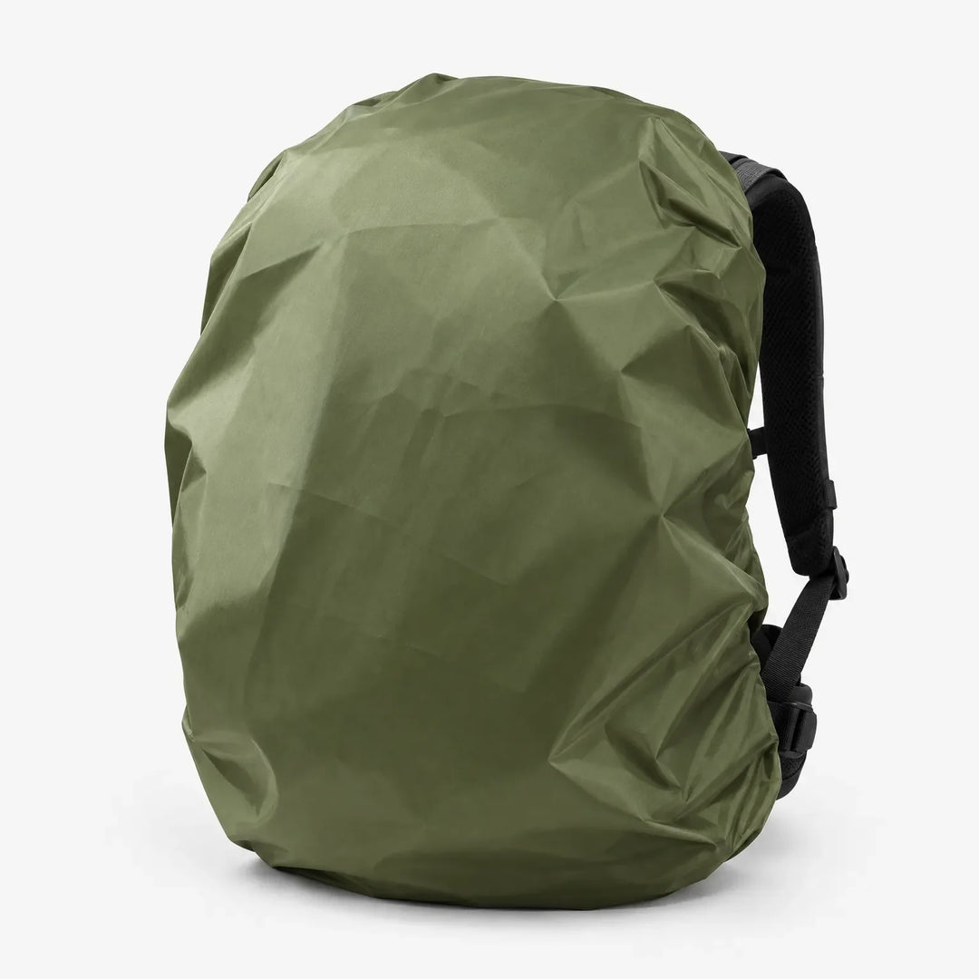 Olive green cover pulled over a backpack in three-quarter view, with a black shoulder strap and buckles visible at the side. 5