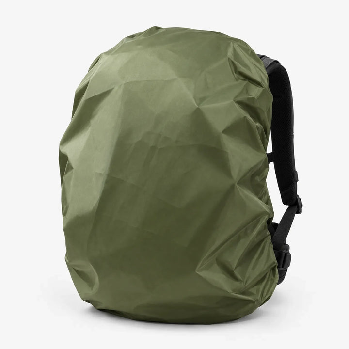 Olive green cover pulled over a backpack in three-quarter view, with a black shoulder strap and buckles visible at the side. 5