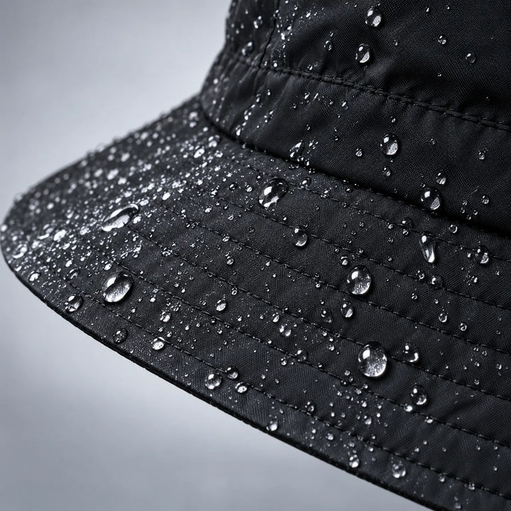 Close-up of a black hat brim and crown with stitched rows and many water droplets sitting on the fabric surface. 6