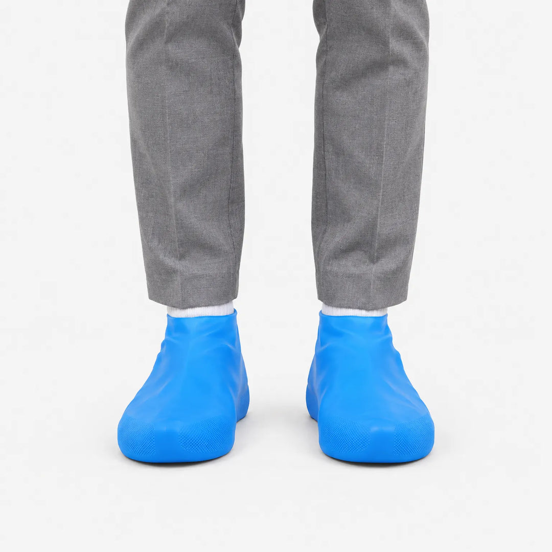 Front view of blue shoe covers worn over shoes with a white sock, against a plain white background. 2
