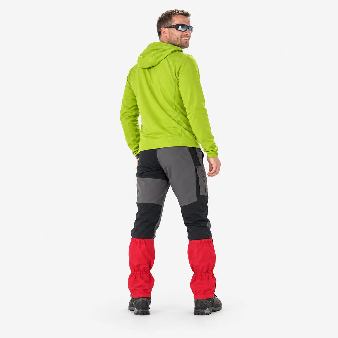 Rear view of a smiling man in a lime green hoodie and sunglasses wearing red gaiters over hiking boots. 4