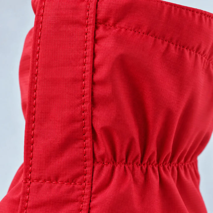 Close-up of the red gaiter fabric showing its fine ripstop weave, reinforced stitched seam and gathered elastic ankle section. 6