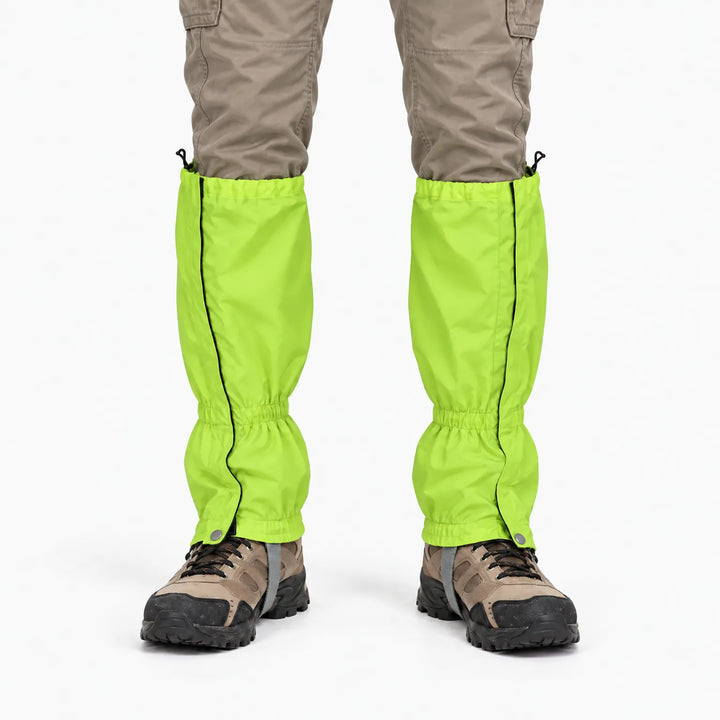Front view of a lime green gaiter pair worn with khaki pants and hiking boots, showing side zips and snap closures. 7