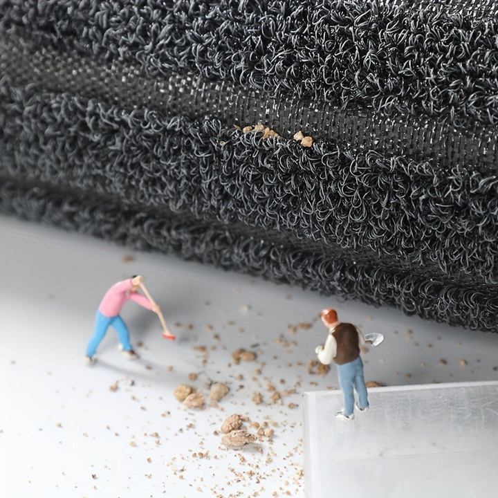 Grey looped pile mat detail showing the woven backing and rolled edge.
