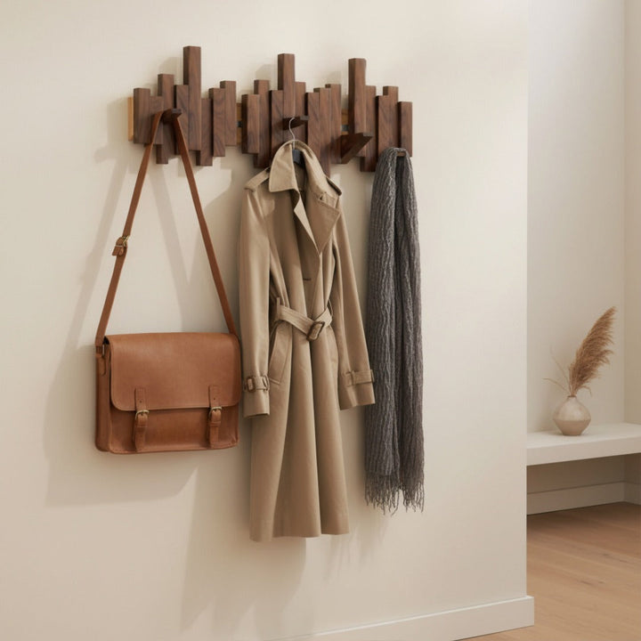 Black wooden piano wall coat rack with folding hooks, another view with a satchel, trench coat and scarf.