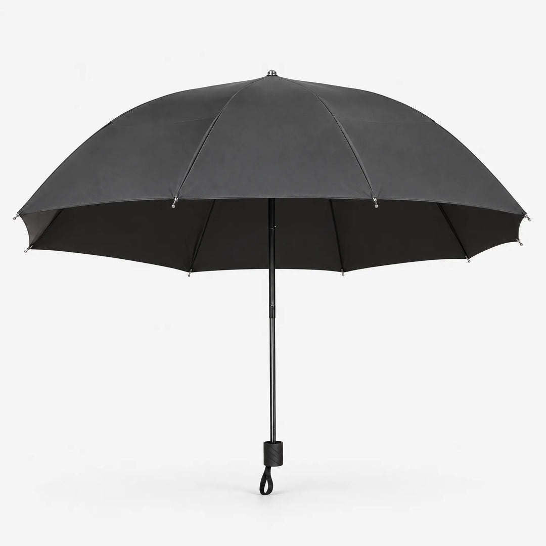 Open dark gray umbrella seen from the side on a white background, showing the black lining, metal-tipped ribs and handle with wrist loop. 3