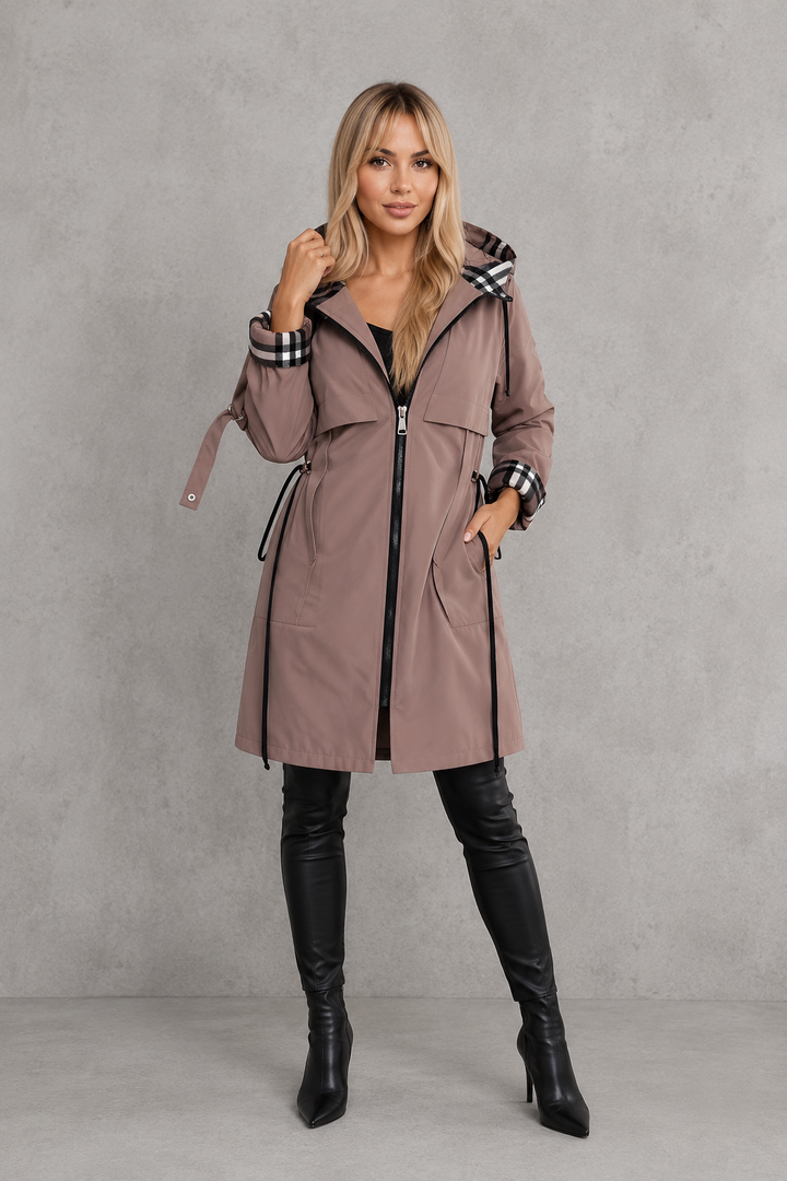 Full-length front view of the mauve coat zipped up with long side drawstrings, chest flap pockets and black knee-high boots. 7