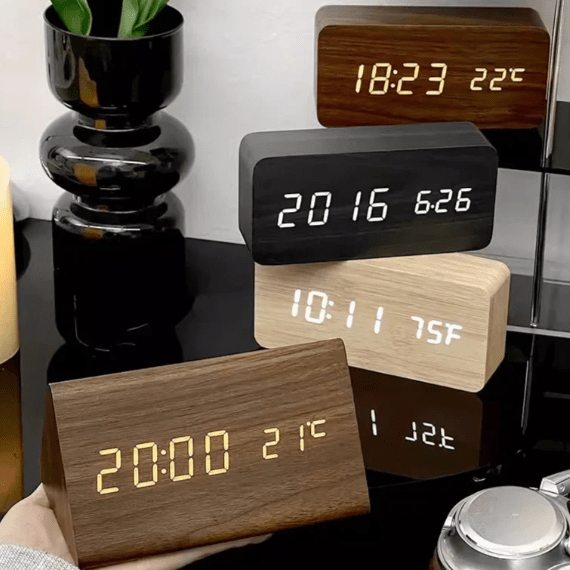 Four wood-grain LED clocks in dark brown, black and light wood, both triangular and rectangular.