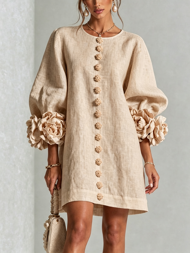 Close front view of the beige dress on a model, showing the flower buttons down the front and sculpted rose cuffs. 23