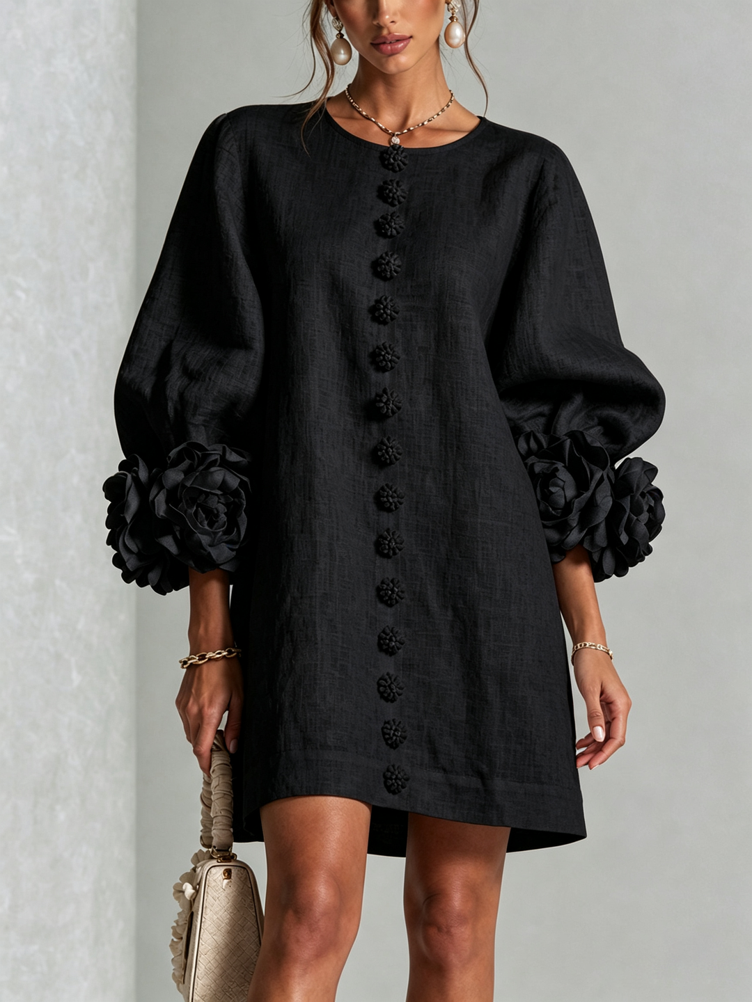 Black dress with black floral buttons and dramatic rose cuffs, front view.