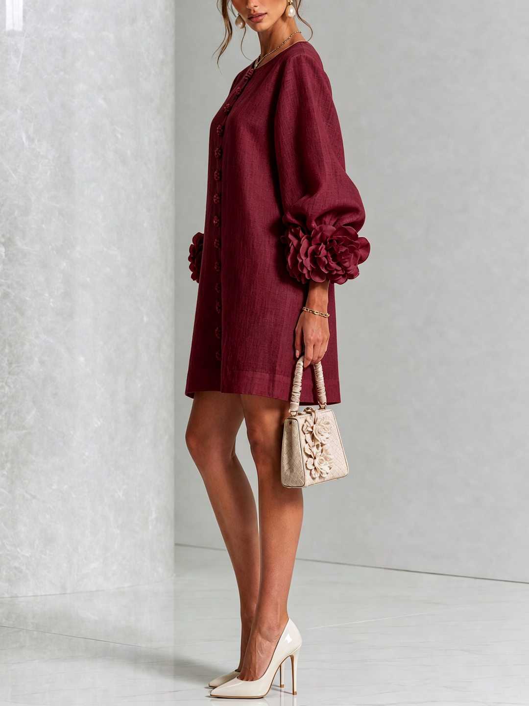 Side view of the burgundy dress with puff sleeves, rose cuffs and a cream handbag 36