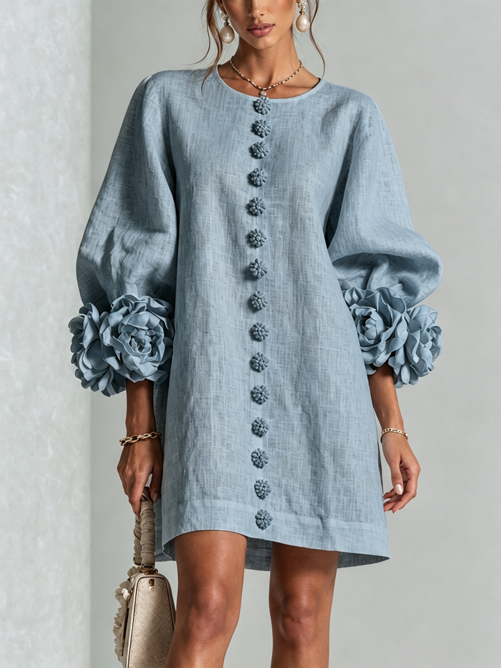 Front view of the light blue dress on a model, showing the row of flower buttons and large rosette cuffs. 41