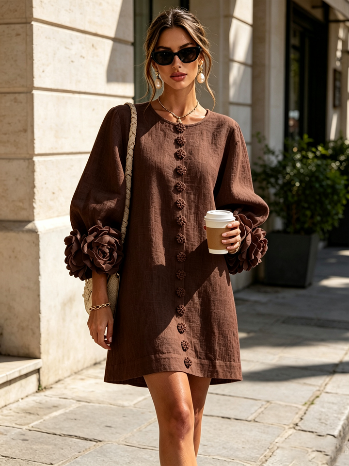 Brown dress worn outdoors on a sunny street, styled with sunglasses, a braided shoulder bag and a takeaway coffee cup. 34