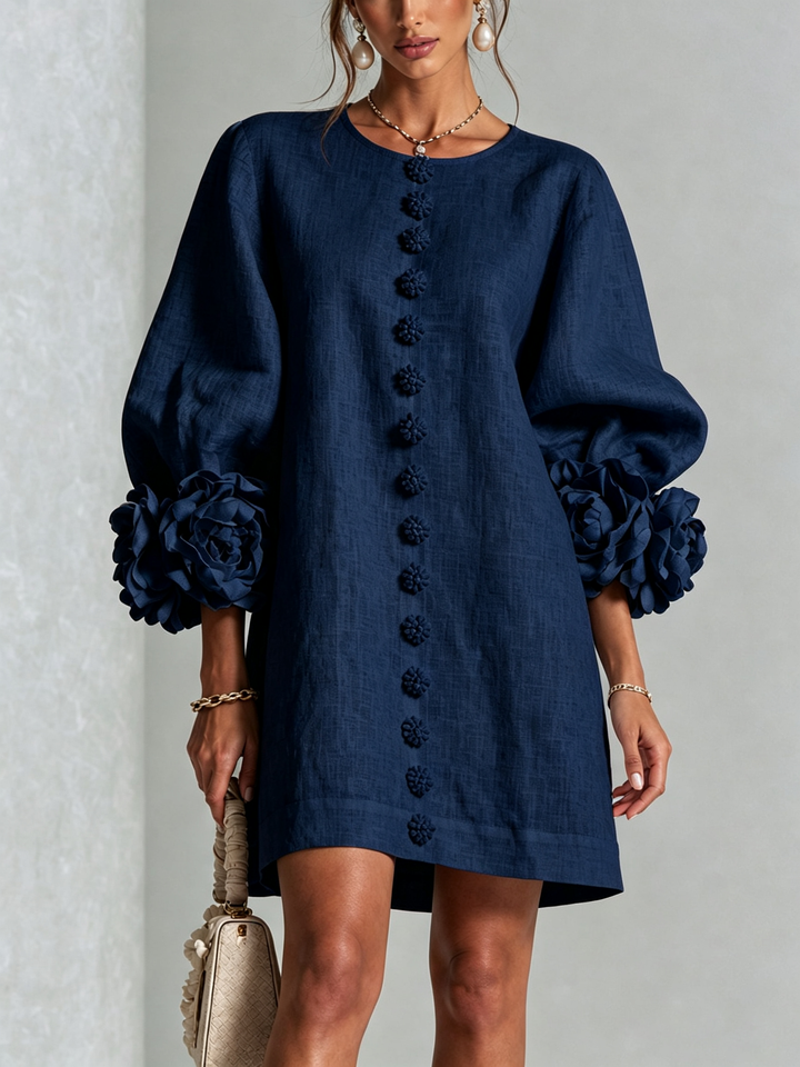 Front view of the navy blue dress on a model, with rose cuffs and flower buttons 11