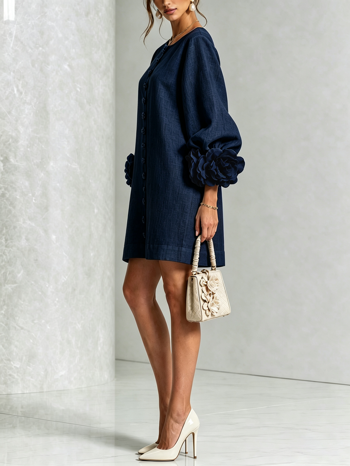 Side view of the navy dress with puffed sleeves, worn with cream heels and a small handbag 12