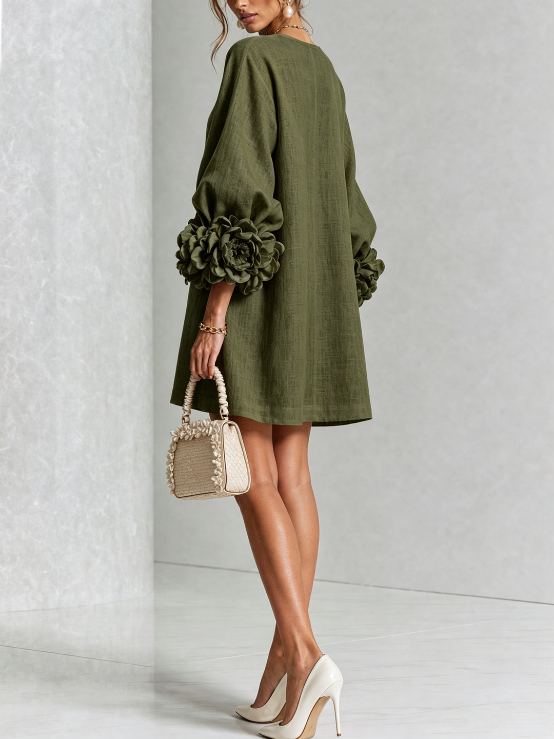 Back three-quarter view of the olive green shirt dress with plain back and rosette cuffs.