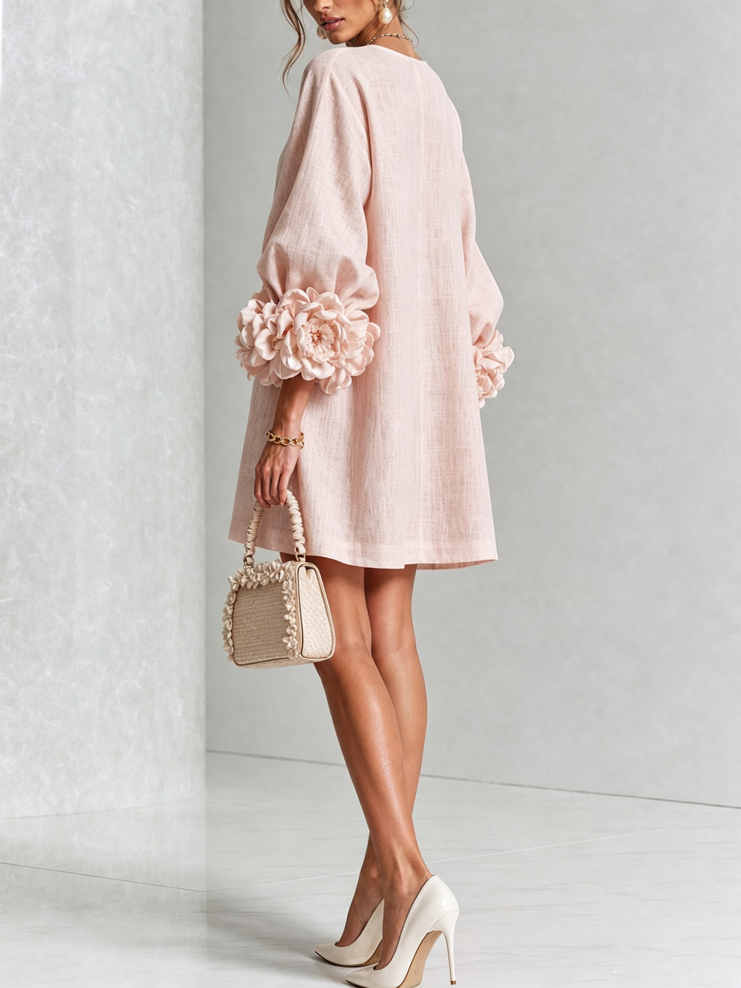 Back view of the pale pink dress on a model, showing large rose cuffs on the puff sleeves 21