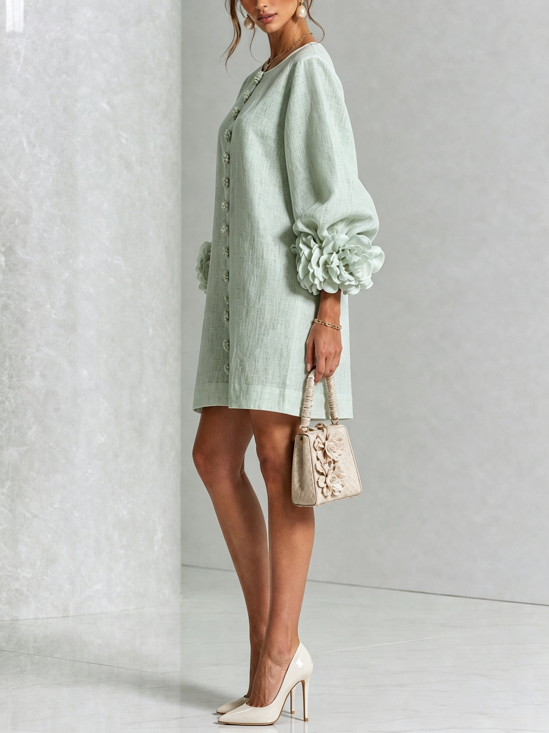 Side view of the mint green dress with puff sleeves, rose cuffs and a cream handbag 32