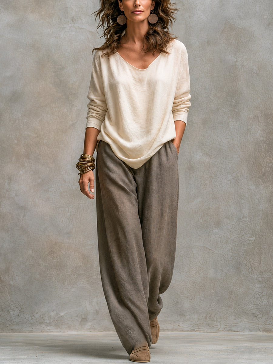 Full-length front view of a model in the cream V-neck long-sleeve top with taupe wide-leg pants, without the cardigan.