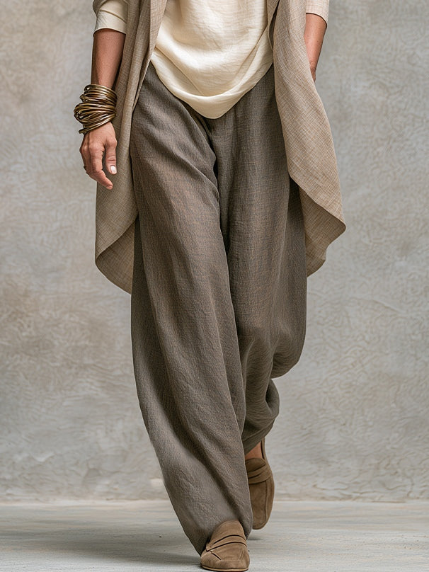 Lower-body detail of the wide-leg taupe pants with a relaxed fit, worn with the cardigan hem and tan loafers.
