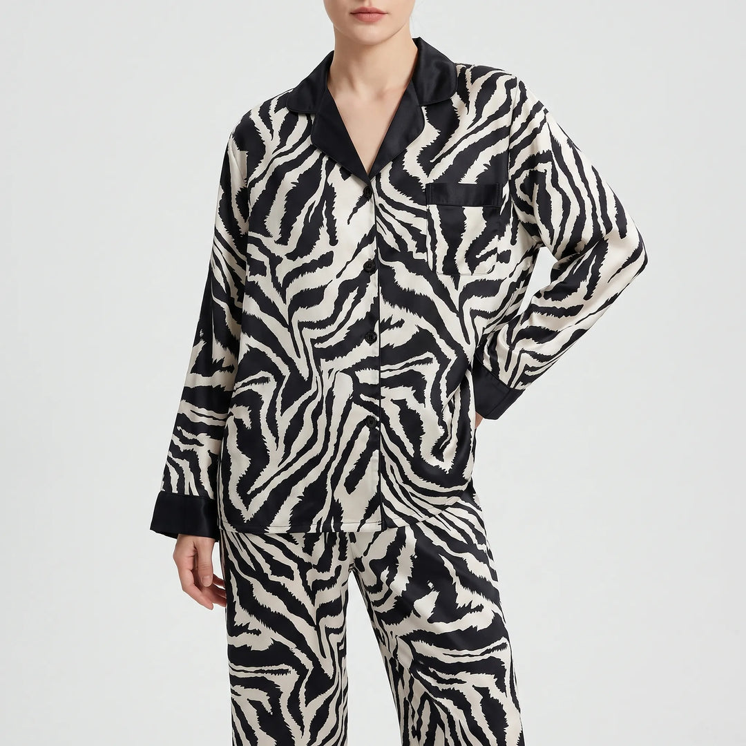 Front view of a model with one hand on her hip in the buttoned long-sleeve zebra-print pajama top and matching pants. 6