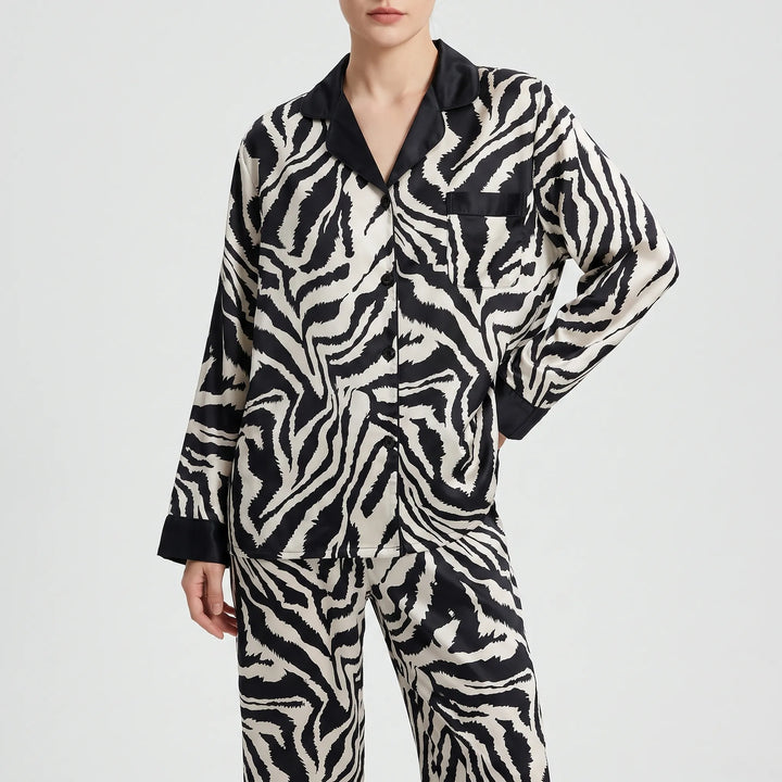 Front view of a model with one hand on her hip in the buttoned long-sleeve zebra-print pajama top and matching pants. 6