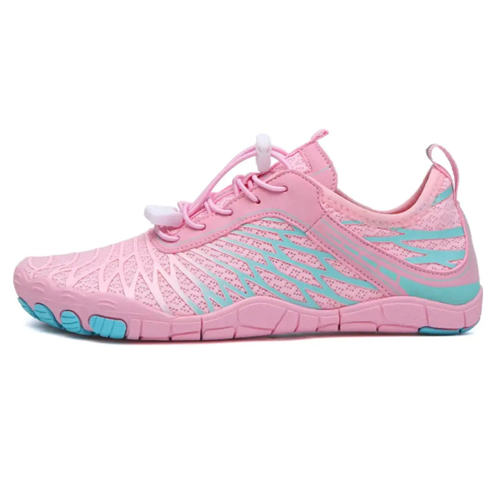 Left-side view of a pink mesh barefoot shoe with turquoise wing-shaped overlays, bungee laces and a flat flexible sole.
