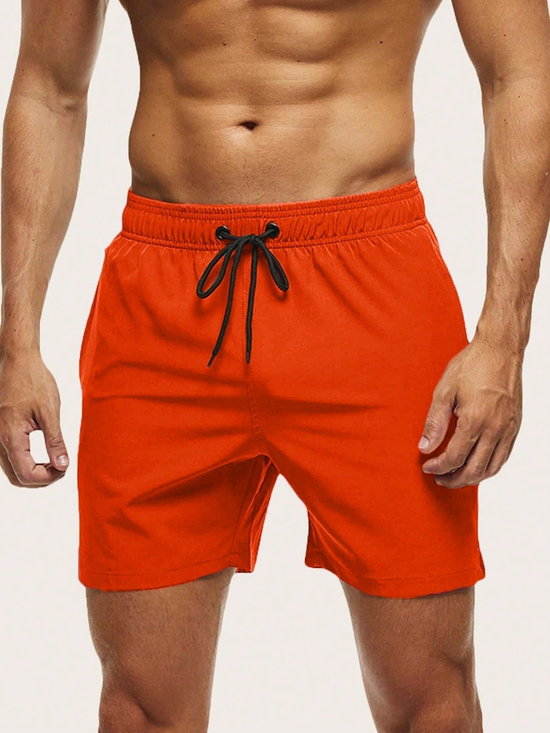 Men's swim trunks in bright orange on a model, front view with black drawstring and elastic waistband.
