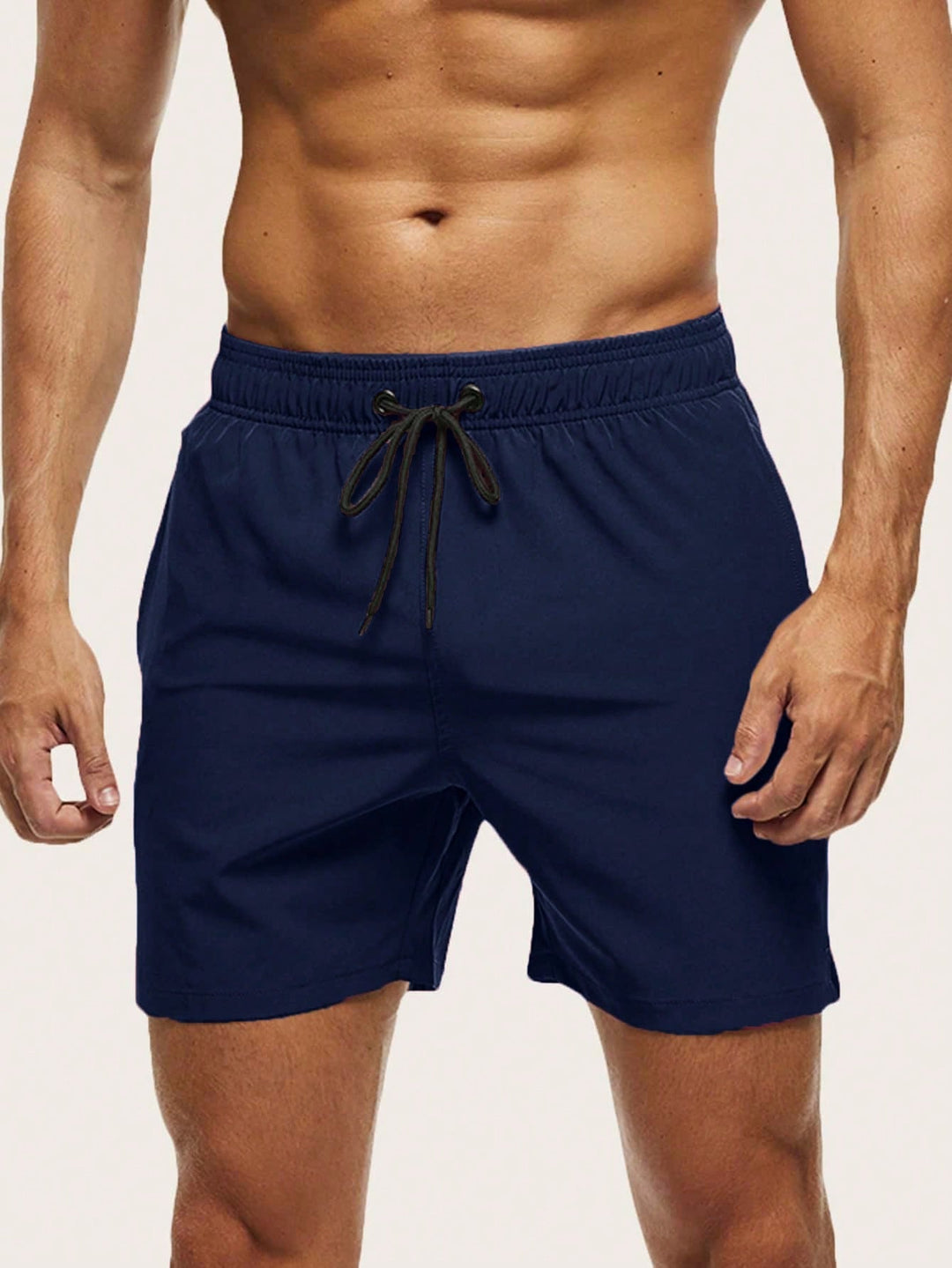 Men's swim trunks in navy blue on a model, front view with black drawstring and elastic waistband.