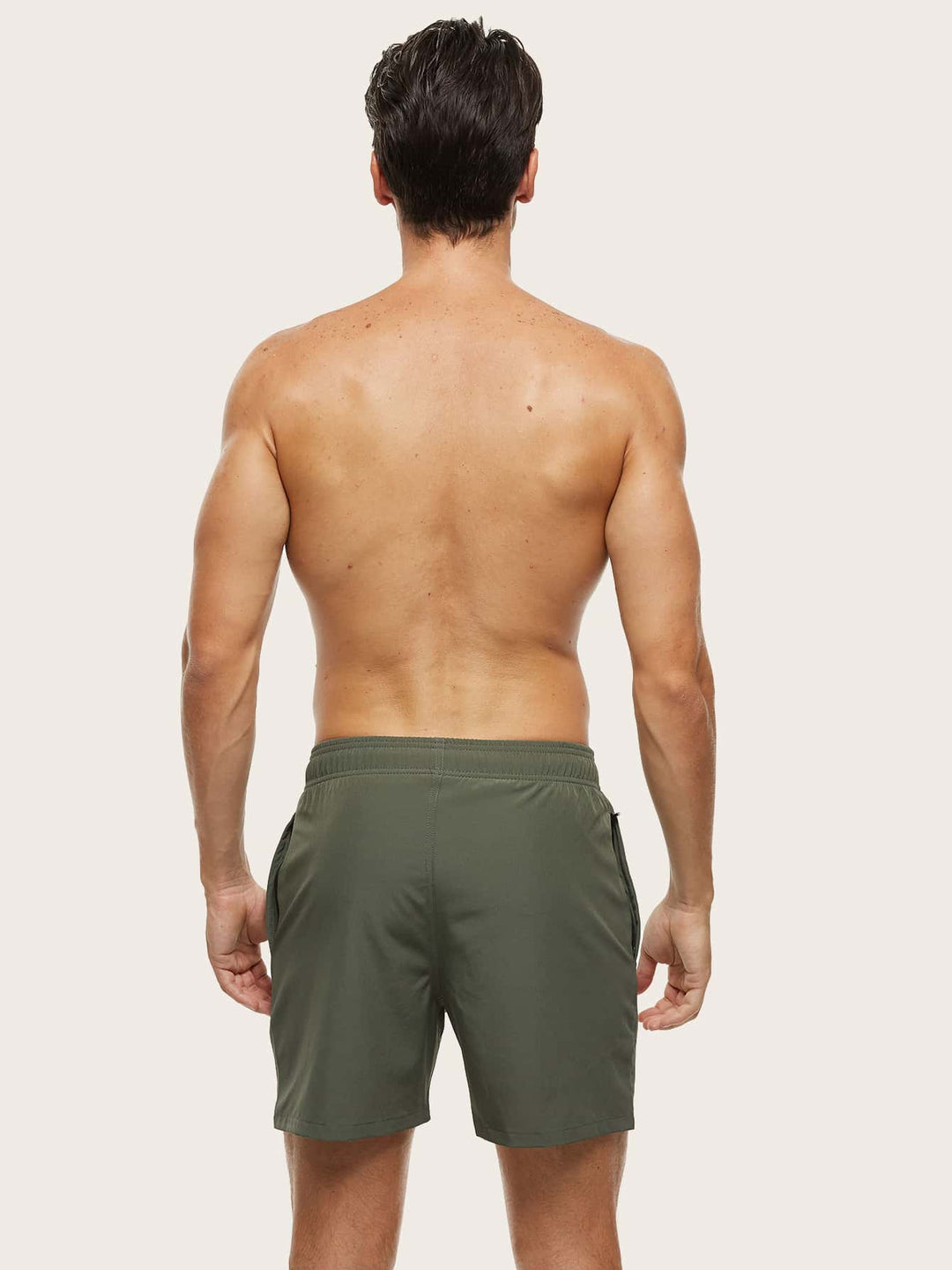 Men's swim trunks in olive green on a model, back view with an elastic waistband and plain rear.