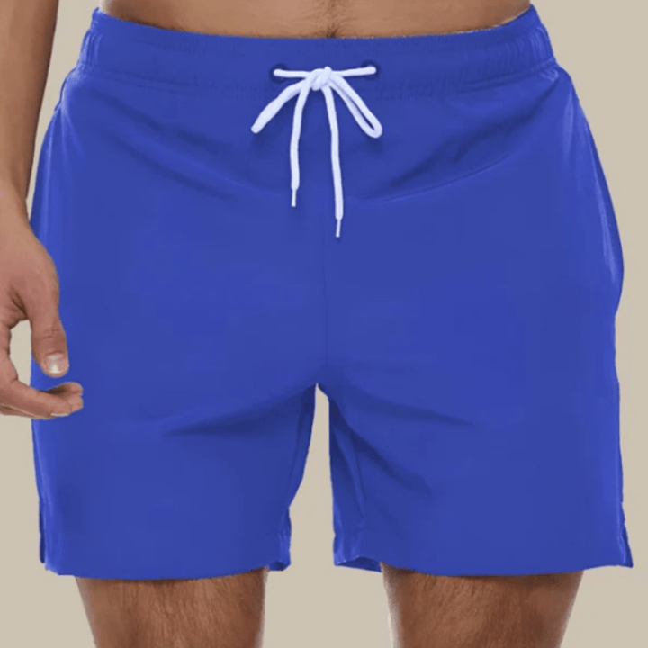Royal blue swim trunks with a white drawstring and small side hem slits, front view.