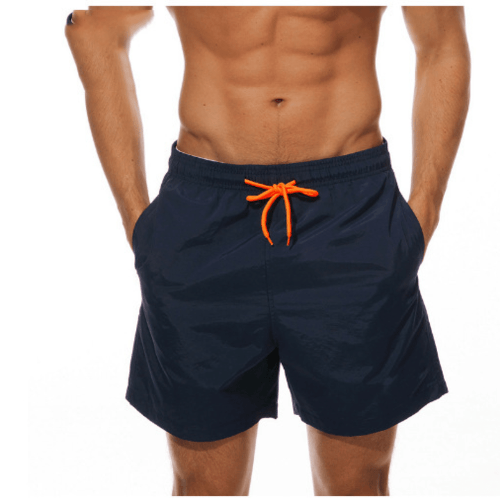 Navy swim trunks with an orange drawstring, front view.