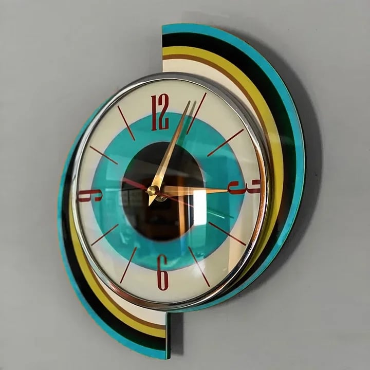 Swirl wall clock detail showing the curved striped backing, domed glass and chrome bezel around the teal and black dial.