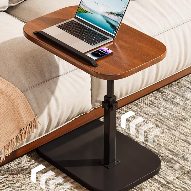 Black rolling laptop desk detail beside a sofa with wheels on the floor