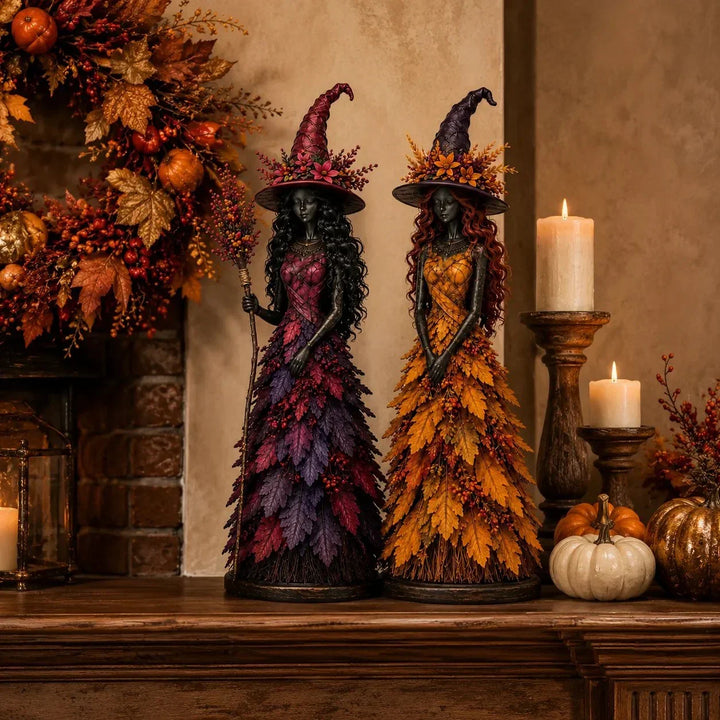 Purple-magenta witch holding a berry broom and a golden-yellow witch on a wooden mantel with candles, pumpkins and an autumn wreath. 5