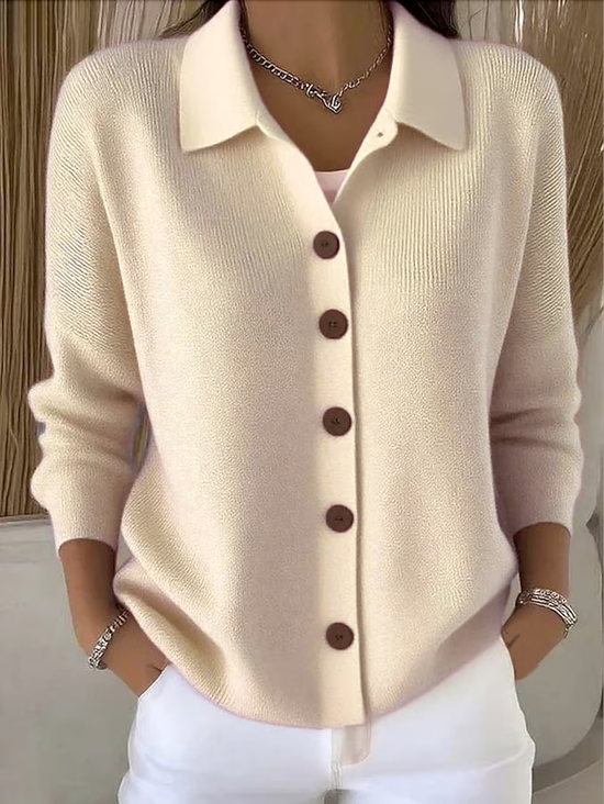 Women's cardigan in cream with brown buttons and a relaxed collar.