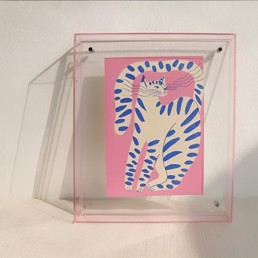 Clear acrylic frame with a pink edge leaning against a wall.