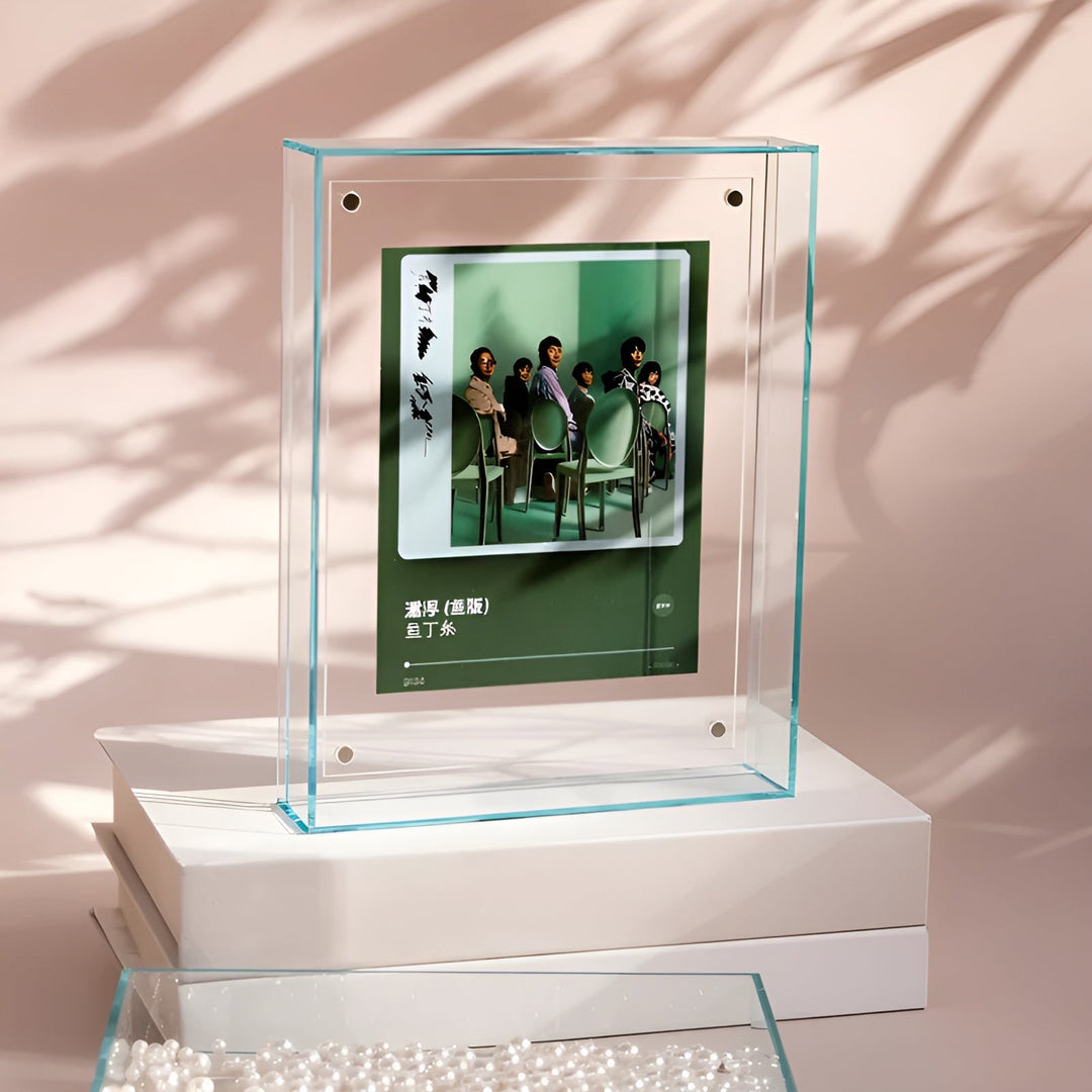 Clear acrylic frame with a light teal tint standing on stacked white boxes.