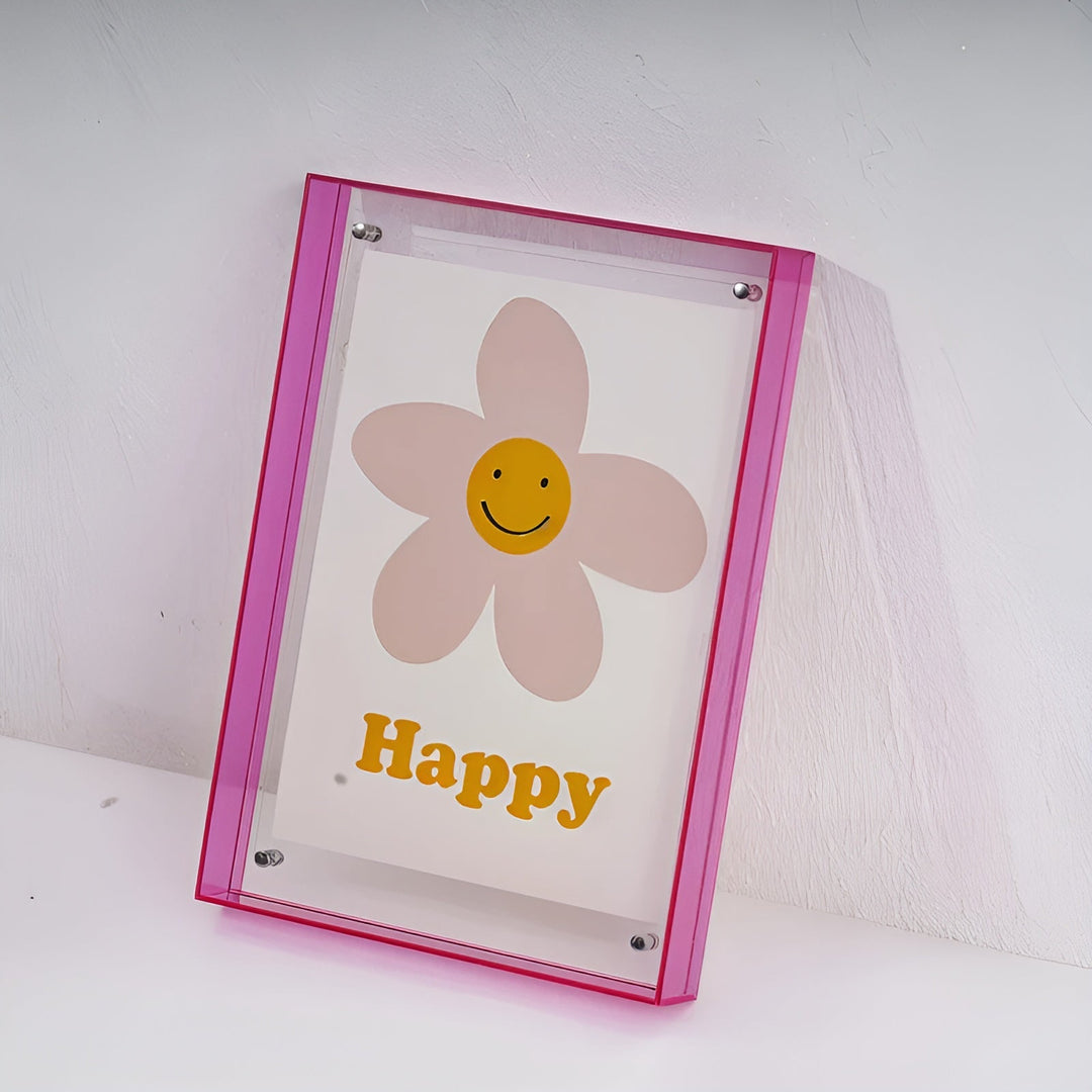 Hot pink acrylic frame leaning against a textured white wall.