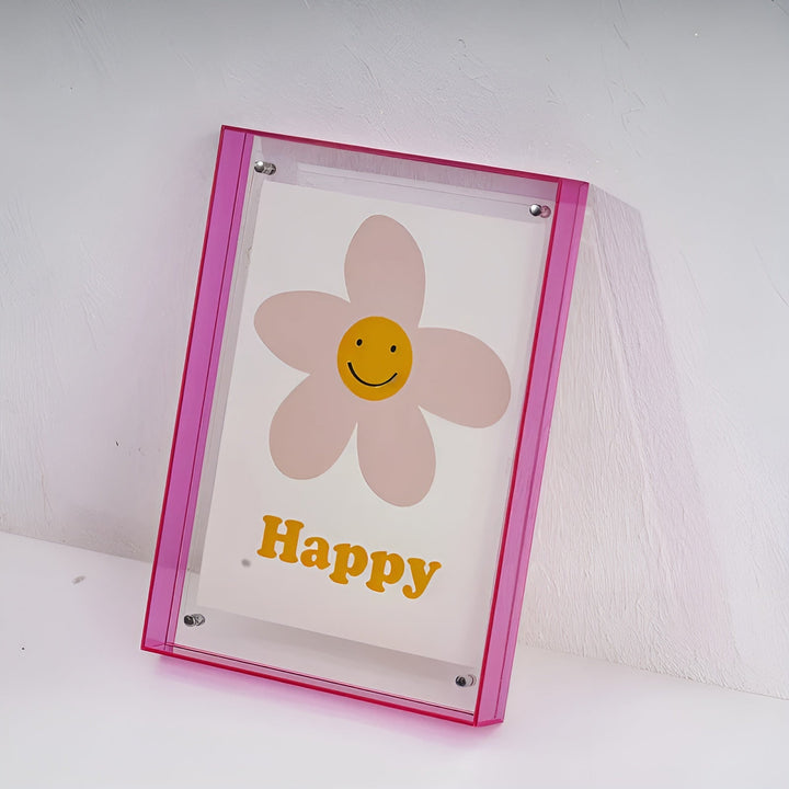 Hot pink acrylic frame leaning against a textured white wall.