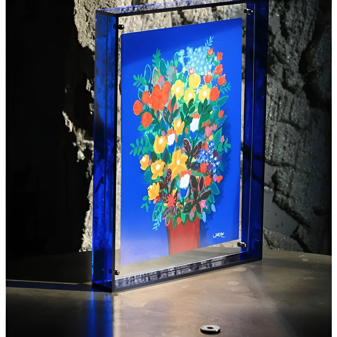 Deep blue acrylic frame in front of a stone wall holding a bold bouquet print.