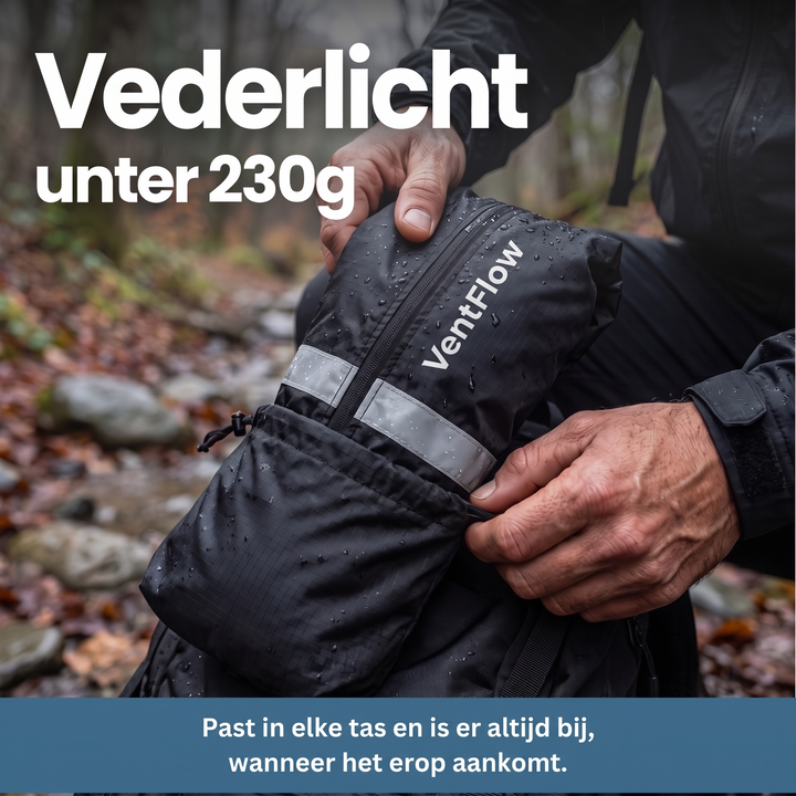 Hands tucking the black jacket, packed small in its drawstring pouch with a reflective band, into a backpack on a wet forest trail.