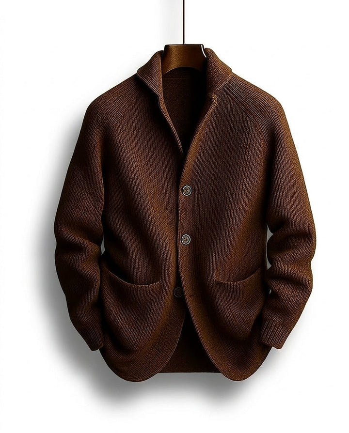 Brown ribbed cardigan with shawl collar, three buttons and two patch pockets, hanging on a wooden hanger 1